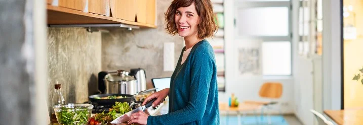 Person schneidet Gemüse in der Küche